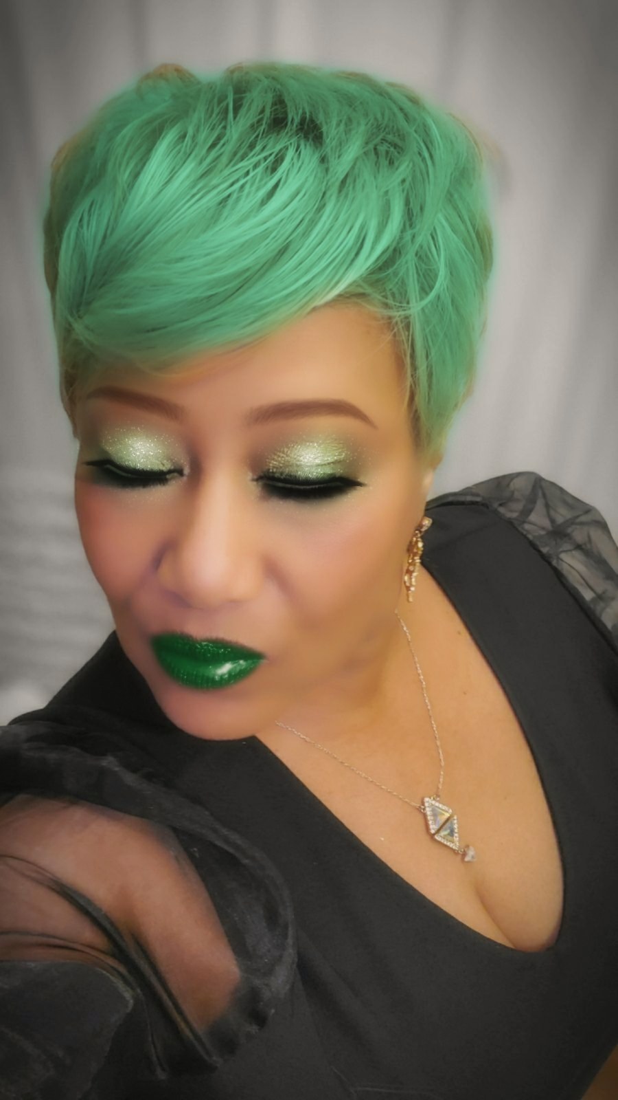 Trané N'Chel with mint green hair and gold jewelry